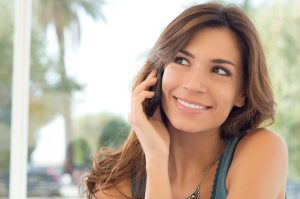 Portrait Of A Smiling Beautiful Woman Talking On The Phone - Turn hold time into an engagement tool with Telephonetics. Discover how message on hold boosts customer satisfaction and results