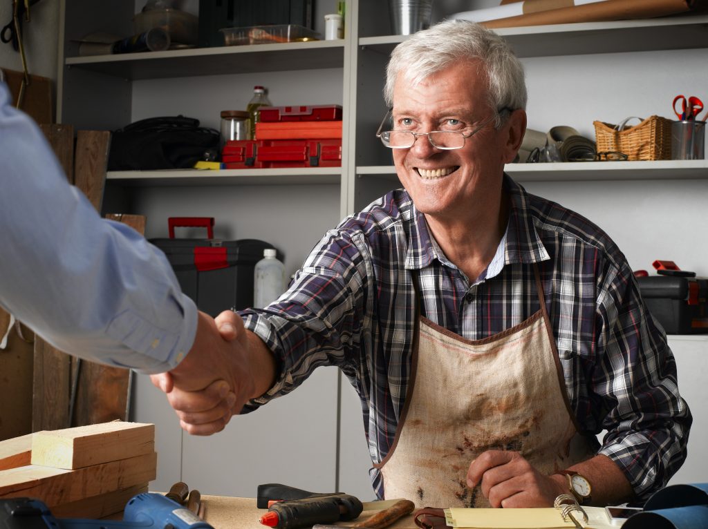 Your existing customers are your most valuable asset - business owner or employee shaking hands with existing customer to convey the importance of customer engagement and customer satisfaction that can be improved with professional messaging on hold.