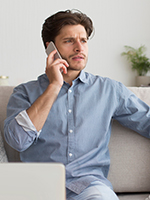 2. Customers Are Waiting Too Long or Getting Lost in the Shuffle - Man looking confused or frustrated on the phone as if he has been waiting too long. Showing the importance of a phone system that can keep up with customer traffic and needs.