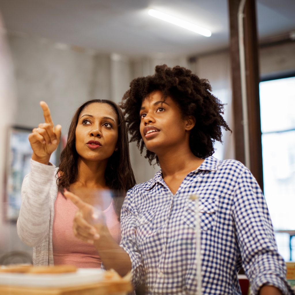 Refreshing overhead messaging for the new year helps ensure your in-location experience feels purposeful rather than passive. - customers shopping in retail store looking at display together